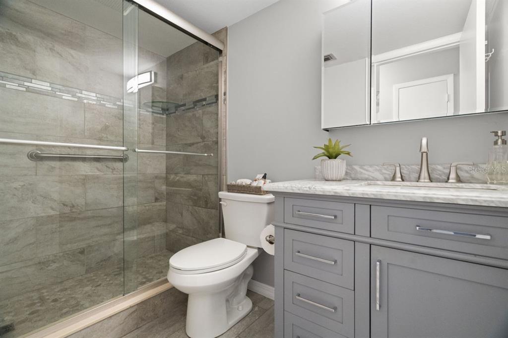 2391 Sumatran Way, Unit 69 Clearwater, FL 33763 - Photo 13 of 50 a bathroom with a sink a toilet and shower