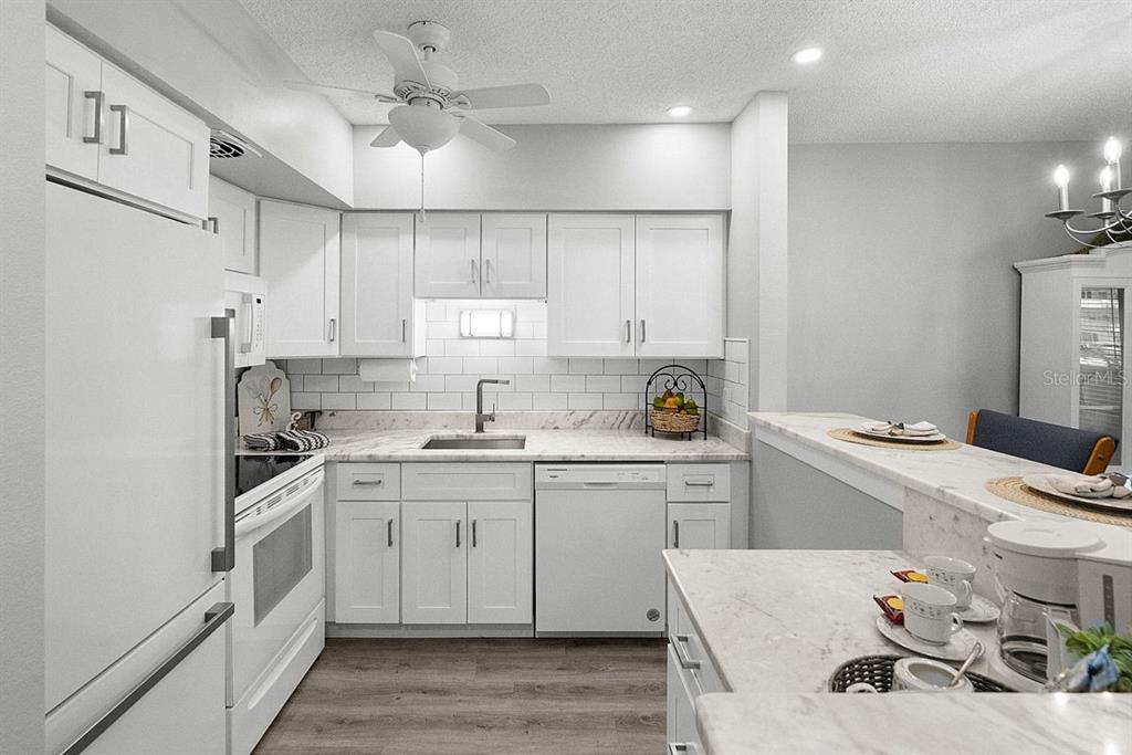 2391 Sumatran Way, Unit 69 Clearwater, FL 33763 - Photo 9 of 50 a kitchen with a sink a stove and cabinets