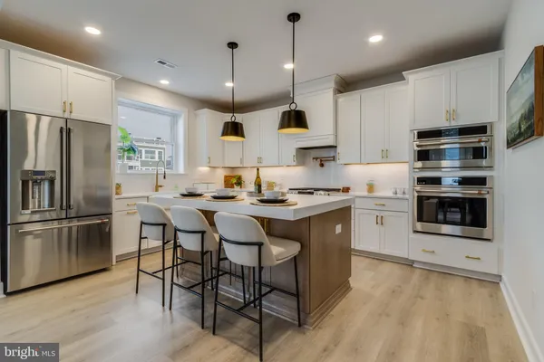 a kitchen with stainless steel appliances granite countertop a sink and a white cabinets