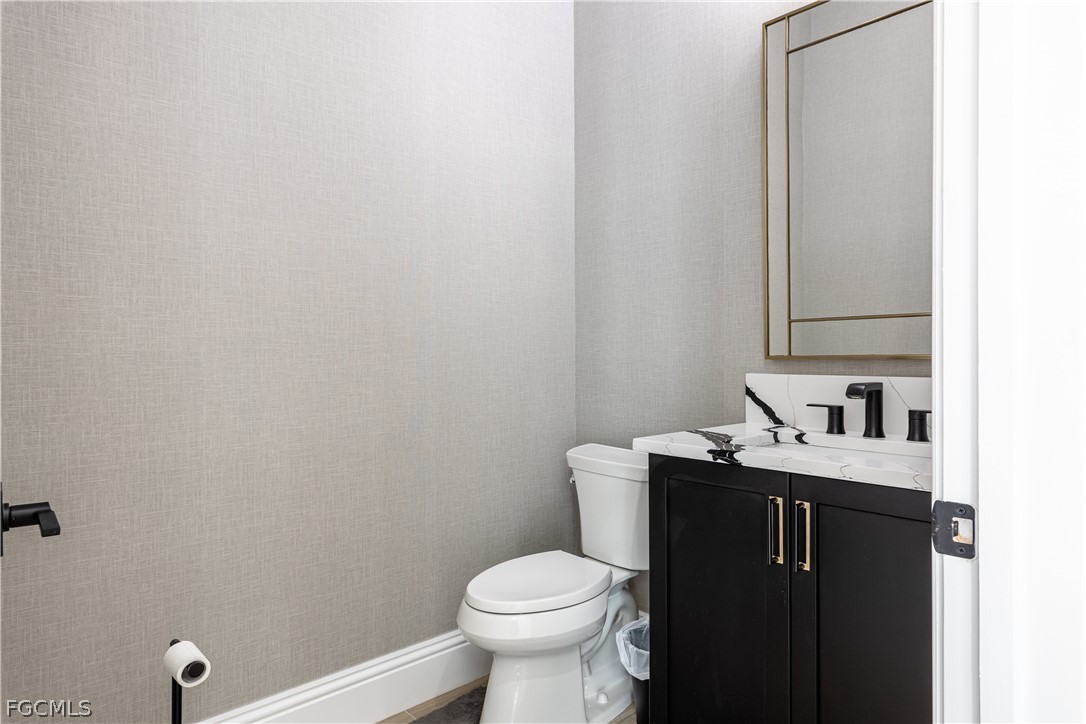 3337 Chestnut Grove Drive Alva, FL 33920 - Photo 6 of 50 a bathroom with a granite countertop toilet sink and mirror