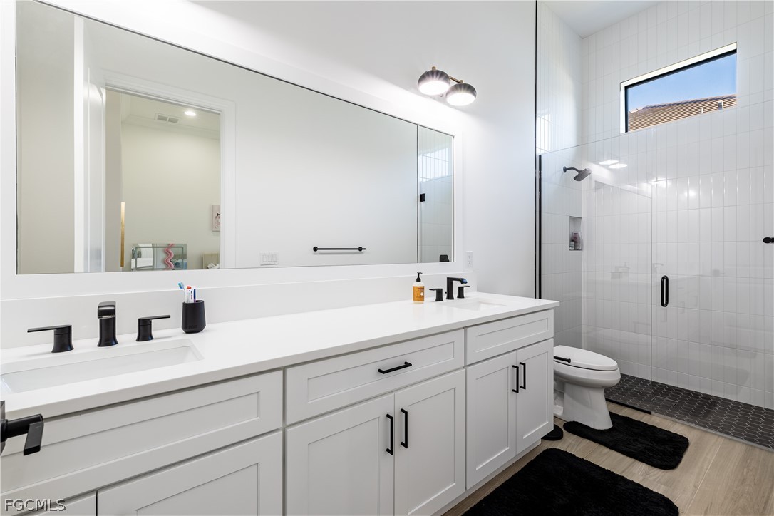 3337 Chestnut Grove Drive Alva, FL 33920 - Photo 10 of 50 a bathroom with a double vanity sink toilet and a mirror