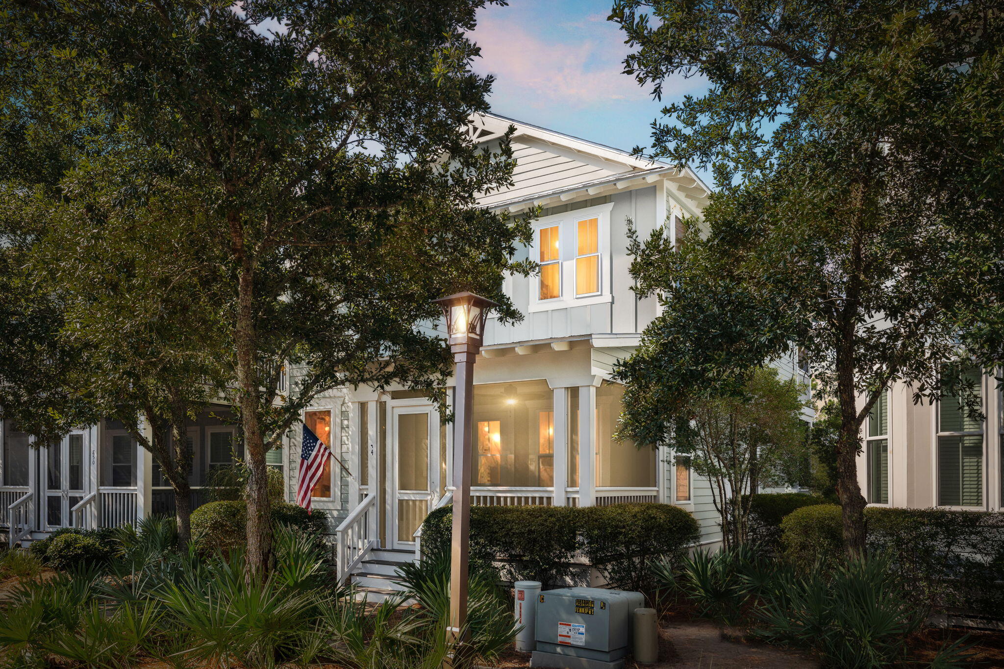 a front view of a house with plants and trees