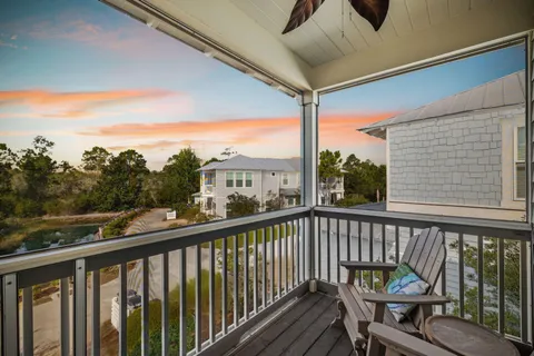 a view of a balcony with wooden floor and outdoor seating