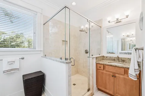 a bathroom with a granite countertop sink a toilet and shower