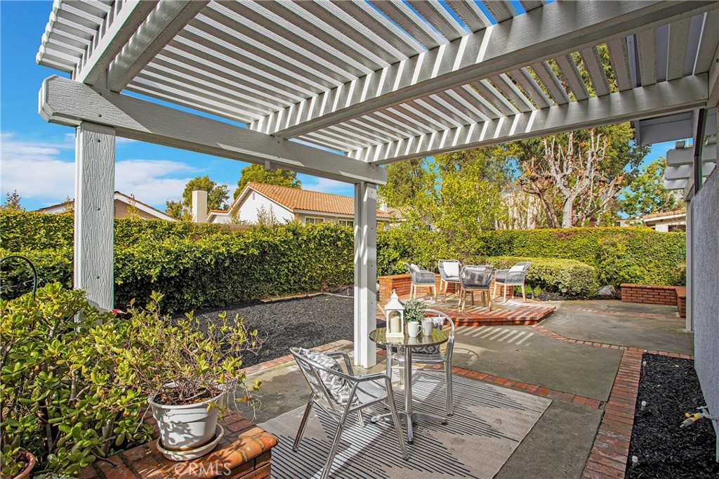 11 Ensueno West Irvine, CA 92620 - Photo 30 of 36 a view of a patio with table and chairs potted plants with wooden floor and fence