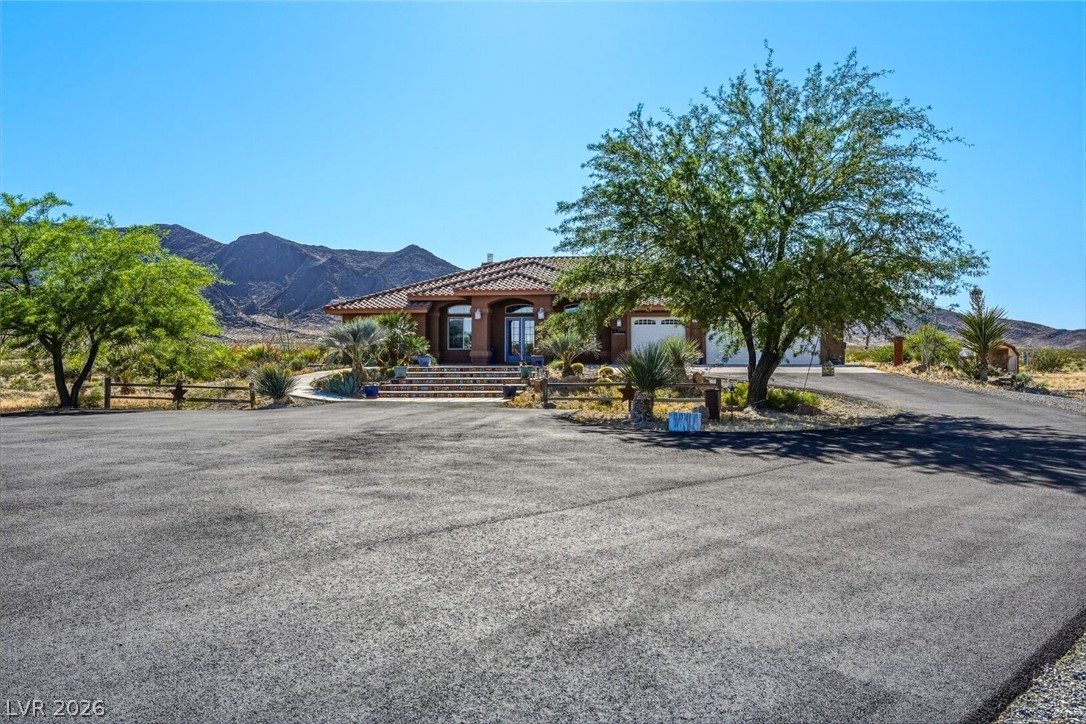4892 Quail Run Road Pahrump, NV 89060 - Photo 11 of 90 This desert oasis features a classic tiled roof and an attached garage, offering both style and utility.