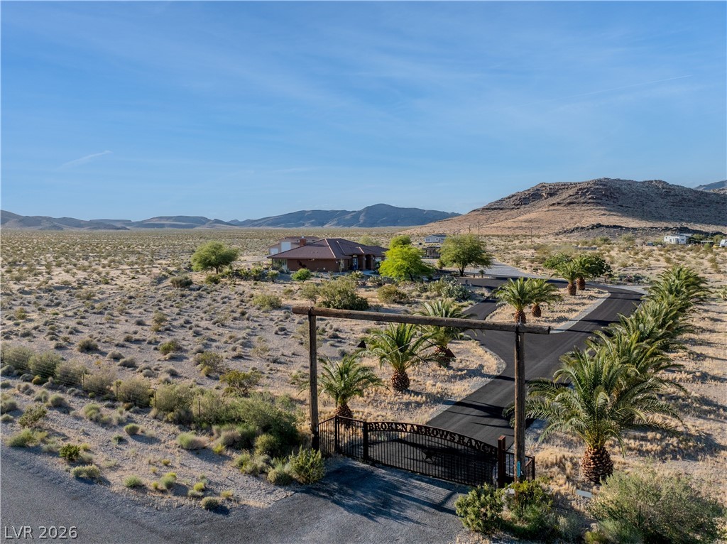 4892 Quail Run Road Pahrump, NV 89060 - Photo 79 of 90 An aerial view showcases a desert property with a private drive leading to a secluded residence.