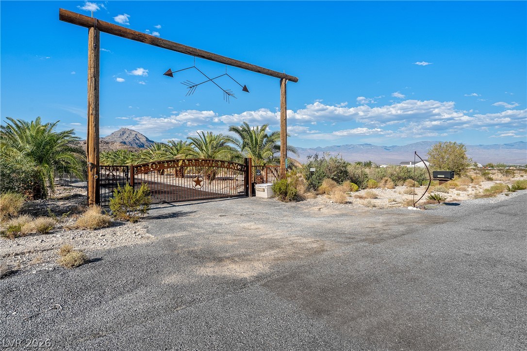 4892 Quail Run Road Pahrump, NV 89060 - Photo 82 of 90 This grand entrance gate welcomes you to a property with desert landscaping and distant mountain views.