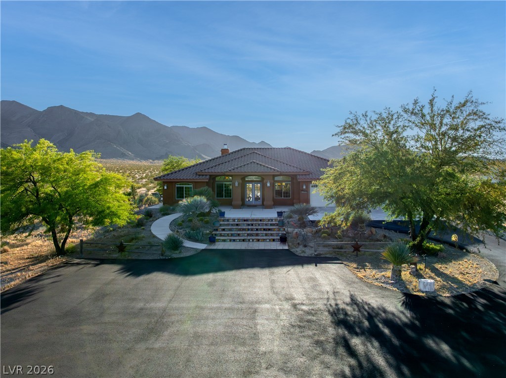 4892 Quail Run Road Pahrump, NV 89060 - Photo 85 of 90 This desert home offers a tranquil escape with scenic mountain views and a welcoming front entrance.