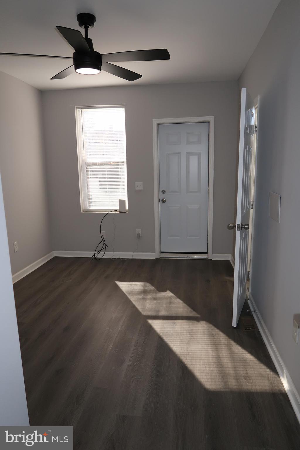 2833 Brendan Avenue, Unit 1 Baltimore, MD 21213 - Photo 11 of 26 an empty room with wooden floor and windows