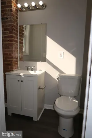 a bathroom with a toilet a sink and mirror