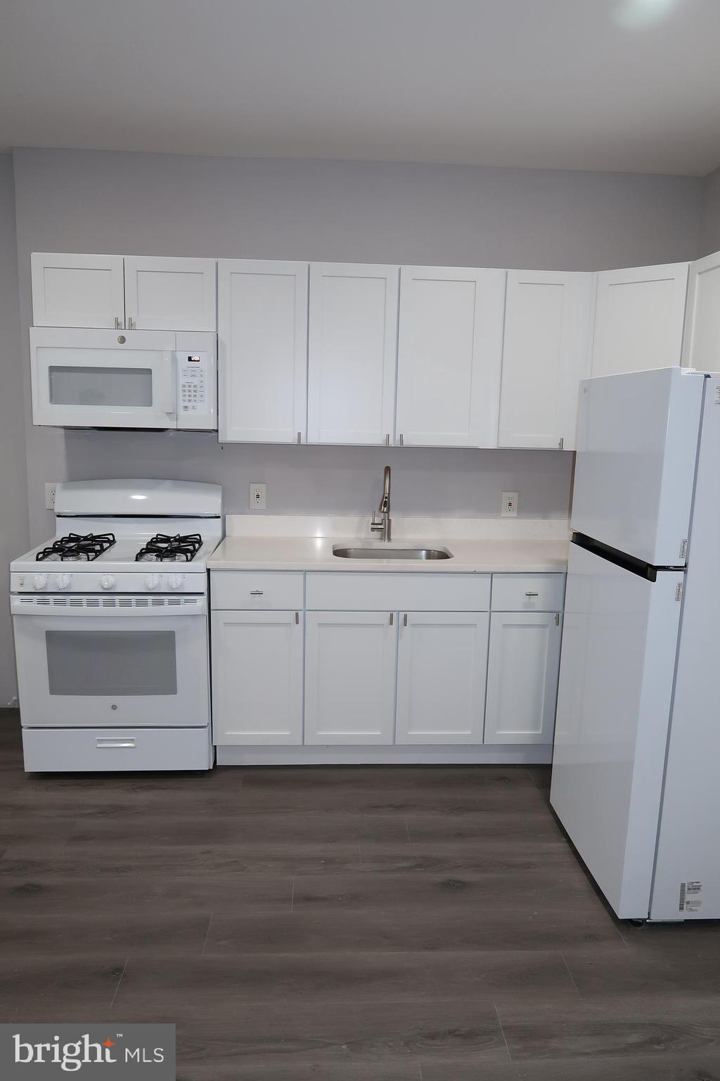 2833 Brendan Avenue, Unit 1 Baltimore, MD 21213 - Photo 4 of 26 a kitchen with cabinets appliances and a wooden floor