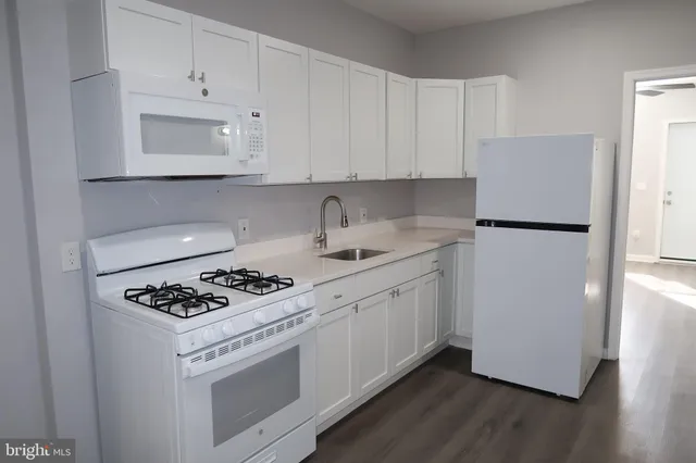 a kitchen with white cabinets and white appliances