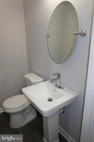 a bathroom with a sink a toilet and a mirror