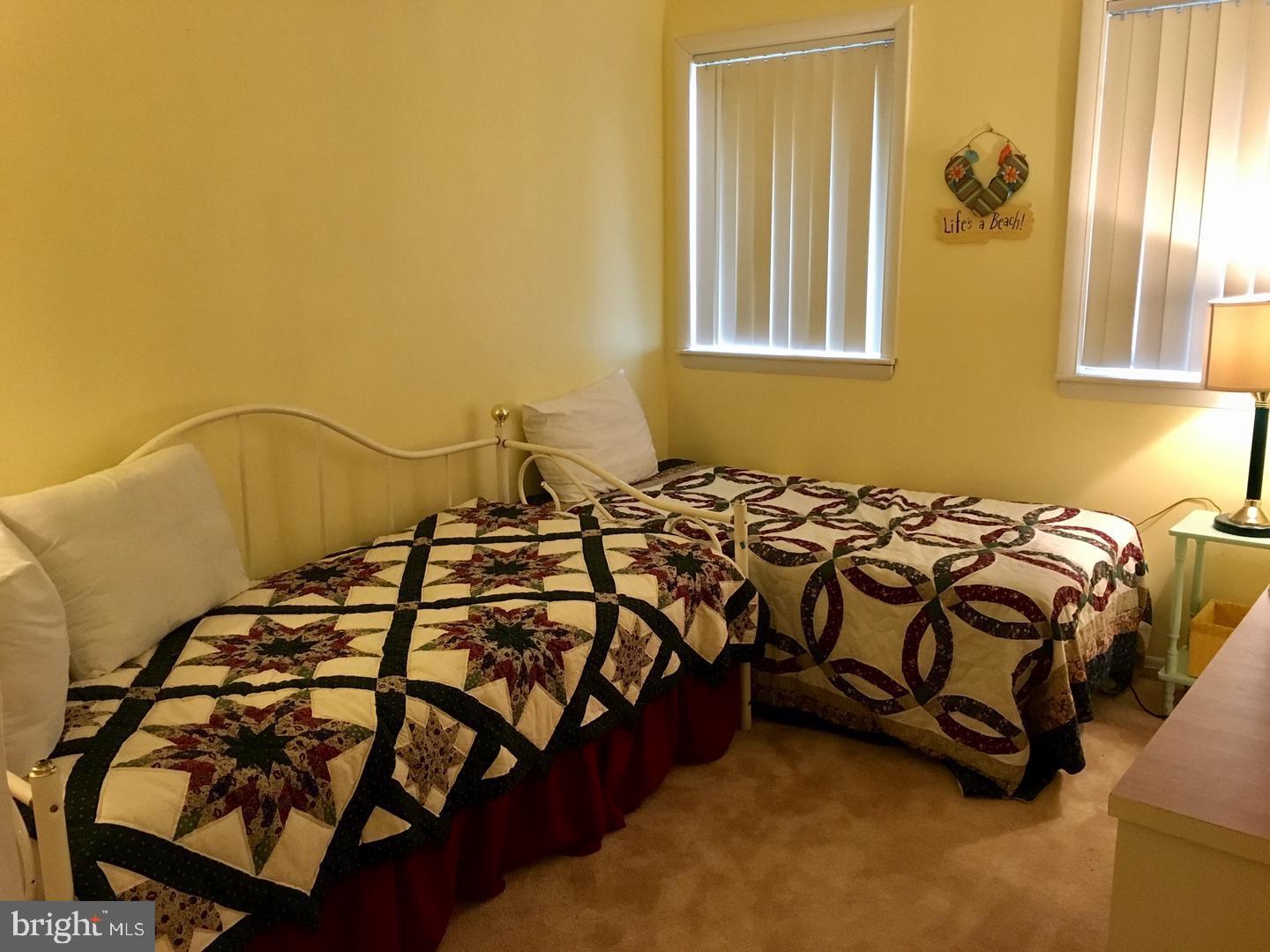 13908 North Ocean Road, Unit 8C Ocean City, MD 21842 - Photo 11 of 14 a bed sitting in a bedroom next to a window