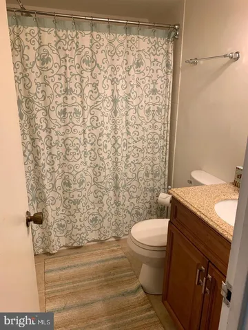 a bathroom with a granite countertop toilet and a shower