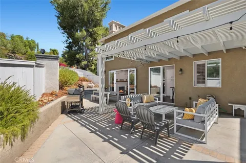 a view of a patio with couches table and chairs potted plants and palm tree
