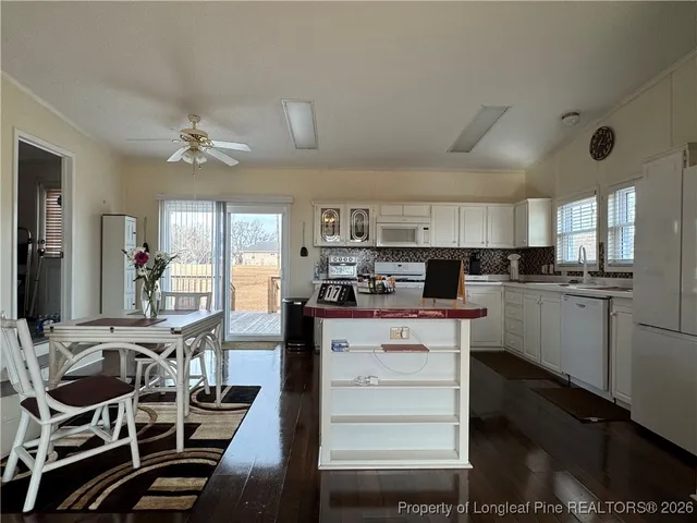 a kitchen with a table chairs refrigerator and cabinets