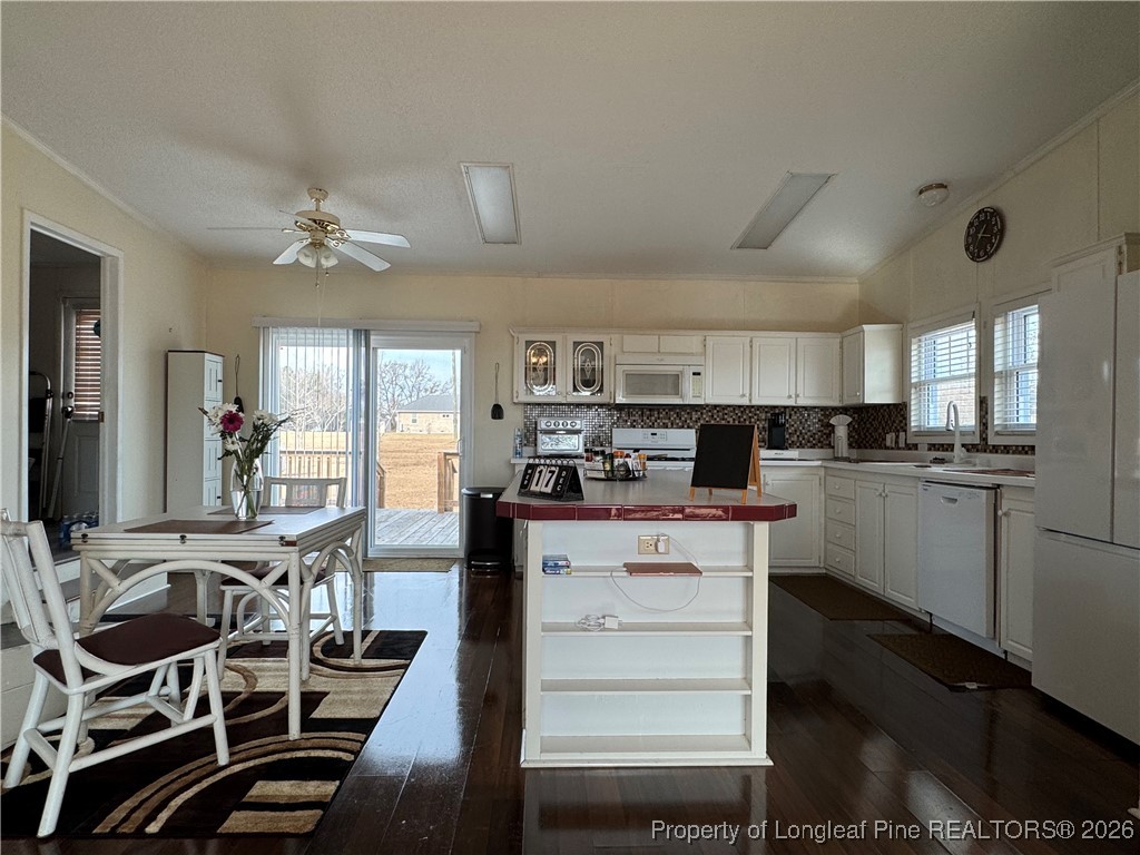 100 Wallace McClean Road Raeford, NC 28376 - Photo 21 of 38 a kitchen with a table chairs refrigerator and cabinets