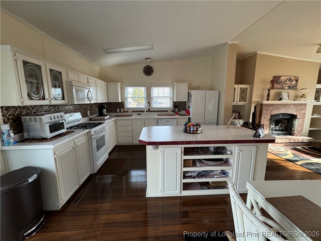 100 Wallace McClean Road Raeford, NC 28376 - Photo 23 of 38 a large kitchen with stainless steel appliances a stove a sink dishwasher and white cabinets with wooden floor
