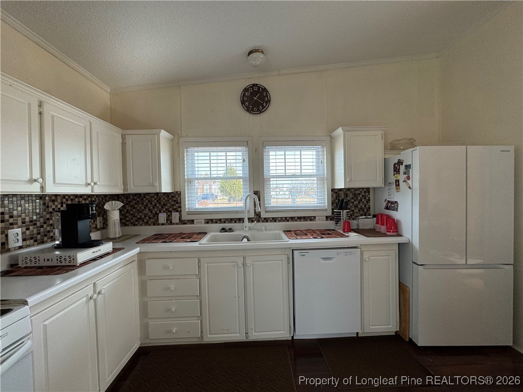 100 Wallace McClean Road Raeford, NC 28376 - Photo 25 of 38 a kitchen with a sink a refrigerator a window and cabinets
