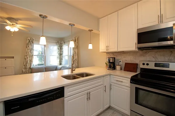 a kitchen with a sink dishwasher a stove and a microwave oven