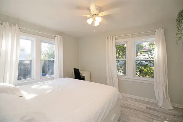 a bedroom with a large bed and a large window with outer view