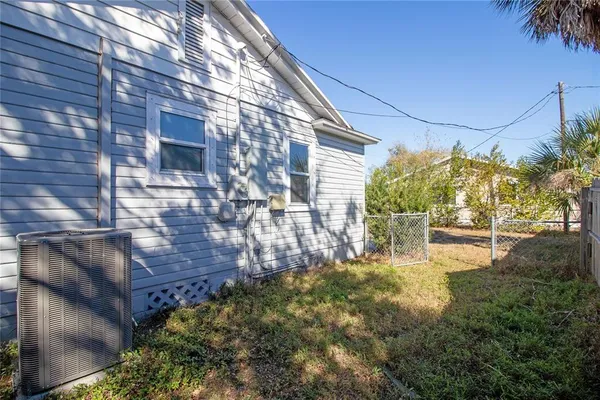 a backyard of a house with table and chairs and potted plants