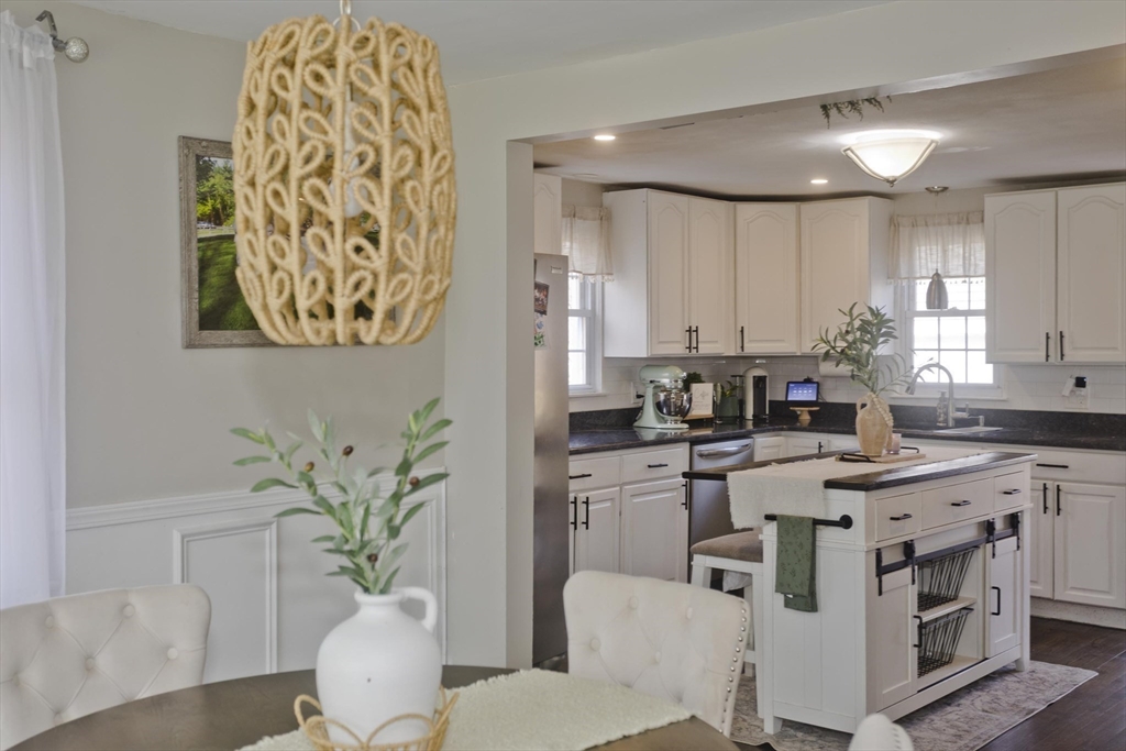 1815 Parker Street Springfield, MA 01128 - Photo 18 of 33 a kitchen with stainless steel appliances a white table chairs and a wooden floor