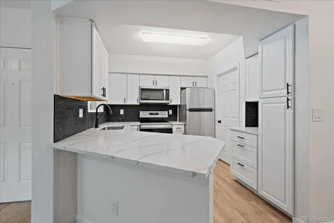 a kitchen with stainless steel appliances a refrigerator and a stove top oven