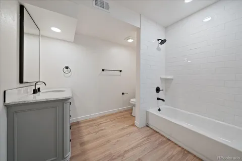 a bathroom with a granite countertop sink a toilet and shower