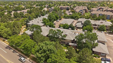 an aerial view of residential houses with outdoor space and trees