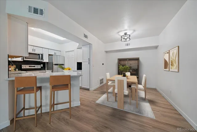 a view of a dining room with furniture a kitchen and chandelier