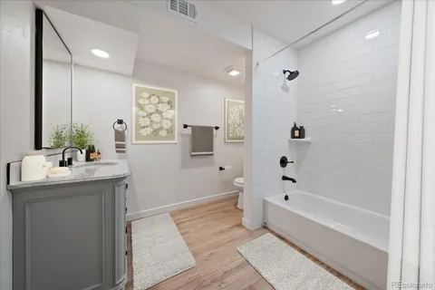 a bathroom with a granite countertop sink a toilet and shower