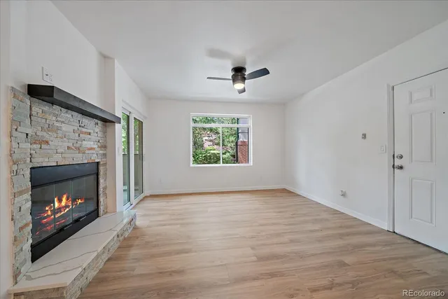 an empty room with windows and fireplace