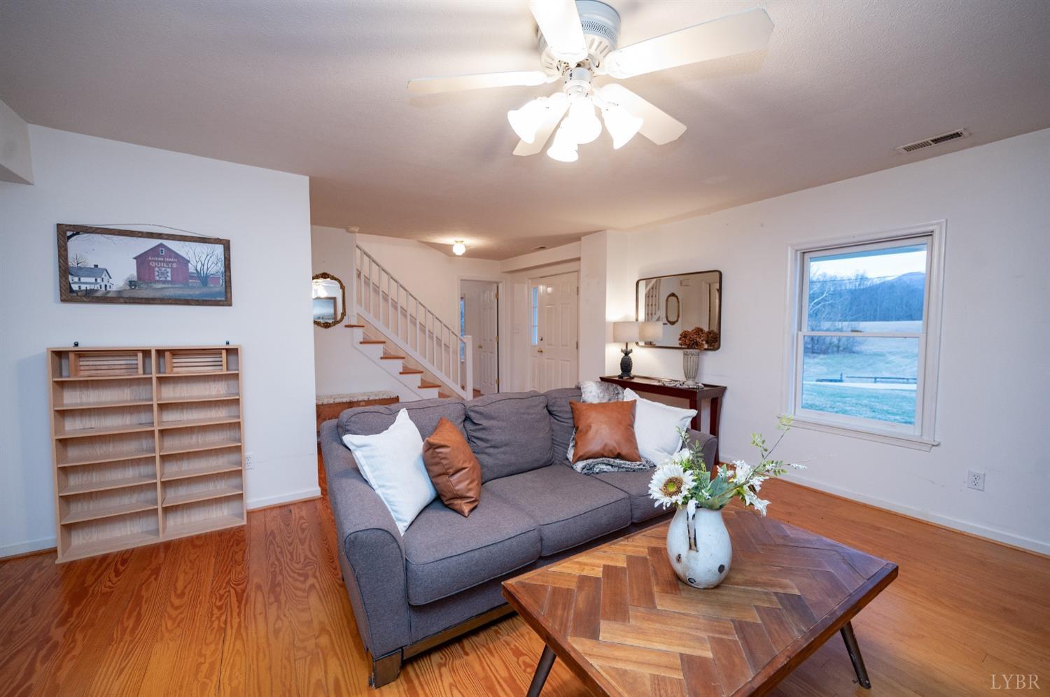 1394 Lowesville Road Amherst, VA 24521 - Photo 14 of 38 a living room with furniture a chandelier and a dining table