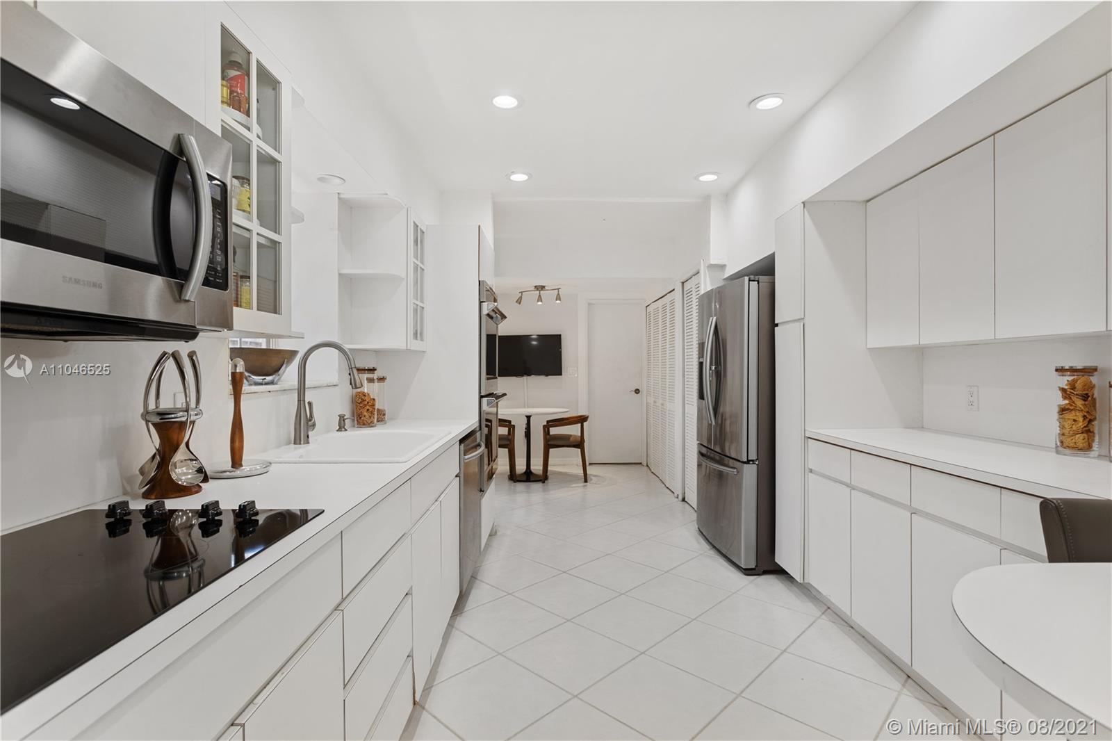 5750 Alton Road Miami Beach, FL 33140 - Photo 15 of 21 a kitchen with stainless steel appliances sink refrigerator and cabinets