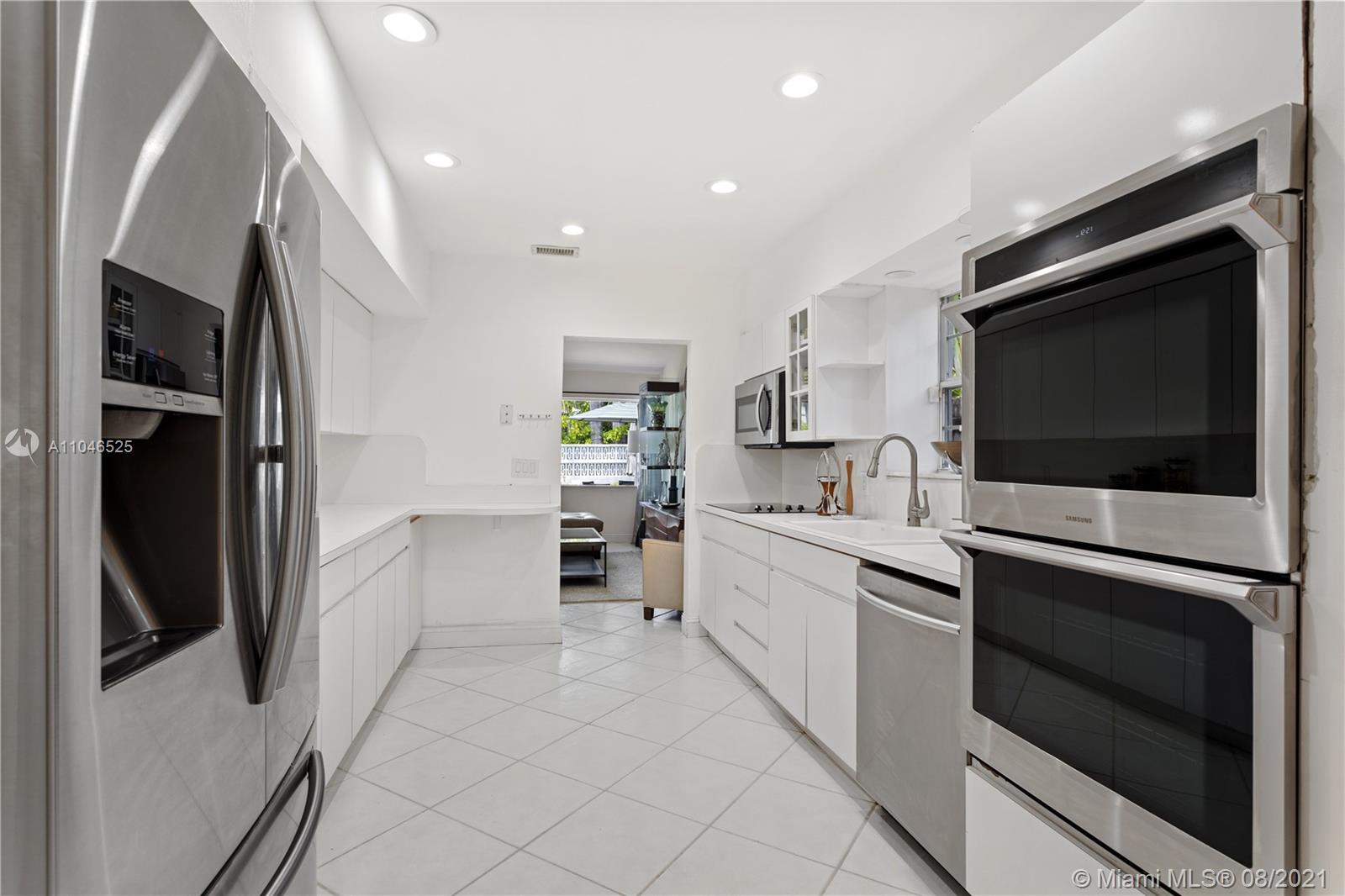 5750 Alton Road Miami Beach, FL 33140 - Photo 16 of 21 a kitchen with stainless steel appliances white cabinets and stove