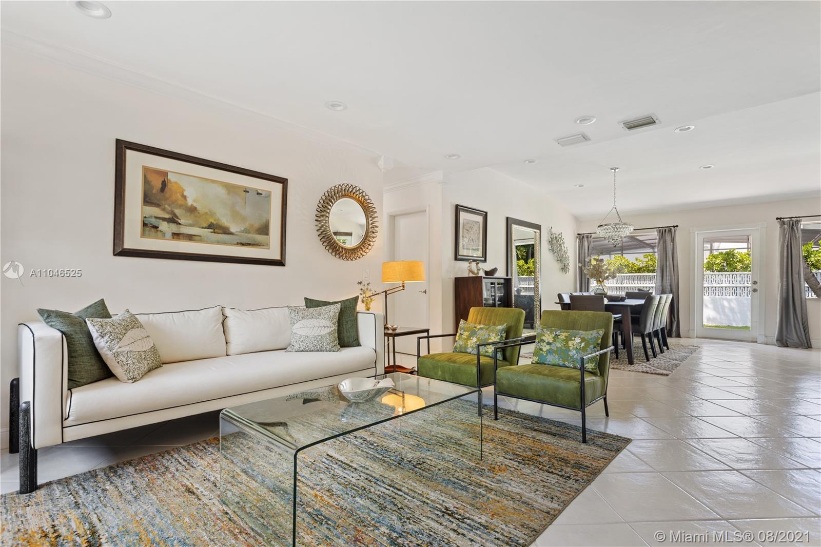 5750 Alton Road Miami Beach, FL 33140 - Photo 4 of 21 a living room with furniture a dining table and paintings on the wall with wooden floor