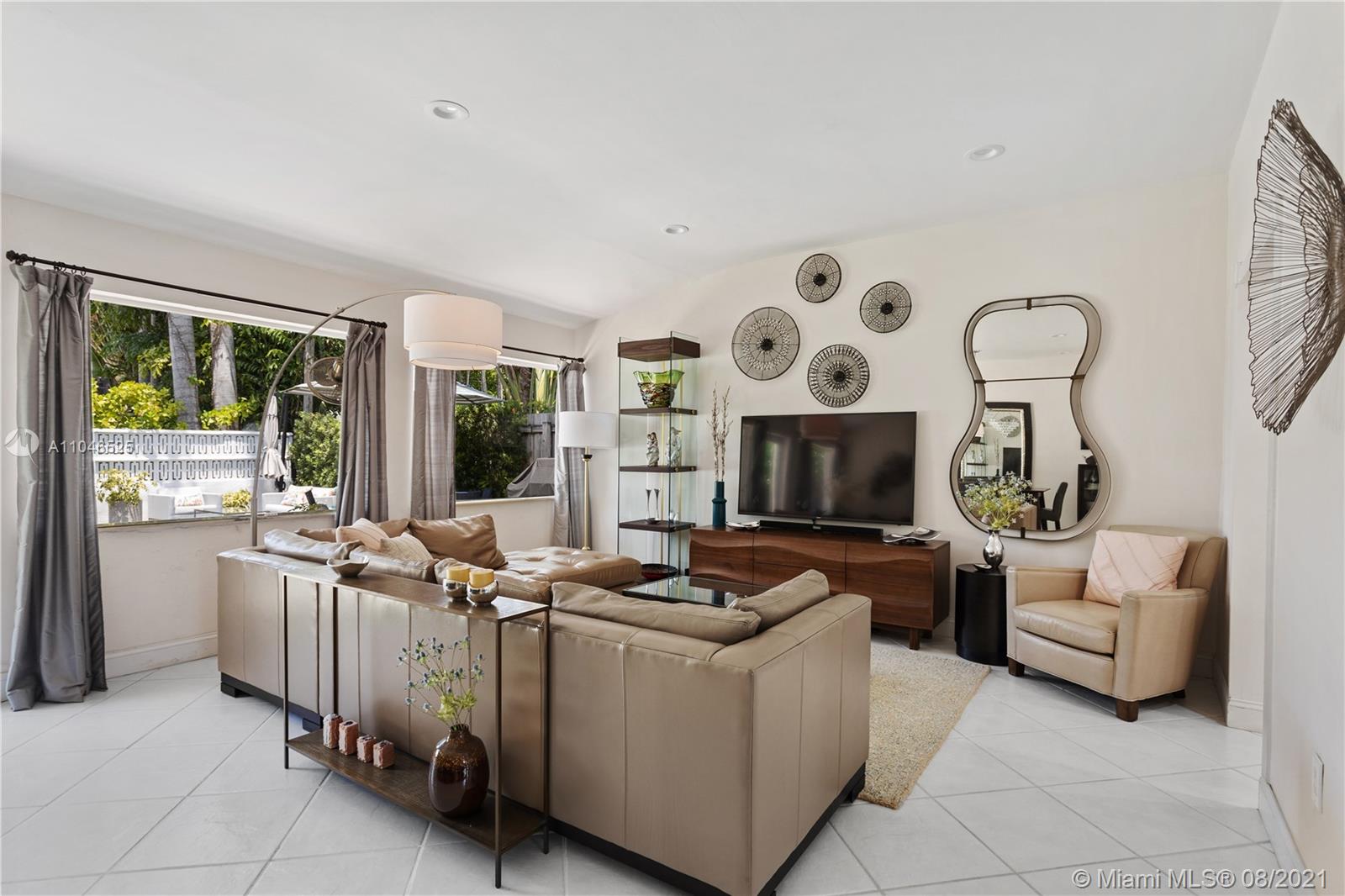 5750 Alton Road Miami Beach, FL 33140 - Photo 5 of 21 a living room with furniture a fireplace and a flat screen tv