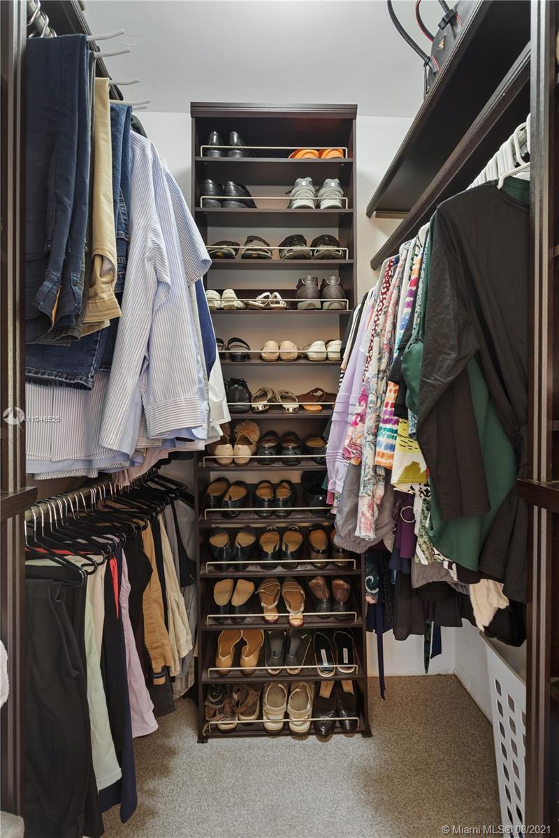 5750 Alton Road Miami Beach, FL 33140 - Photo 9 of 21 a view of walk in closet with clothes and shoes