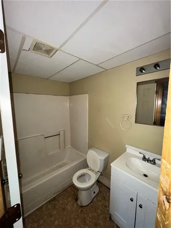 a white toilet sitting next to a bathroom sink and tub
