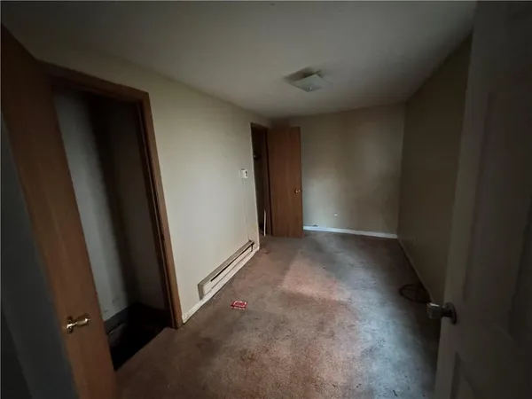 a view of a hallway with wooden floor and closet
