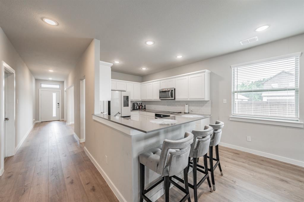 3202 Glorioso Drive Royse City, TX 75189 - Photo 22 of 40 a kitchen with stainless steel appliances a dining table chairs and wooden floor
