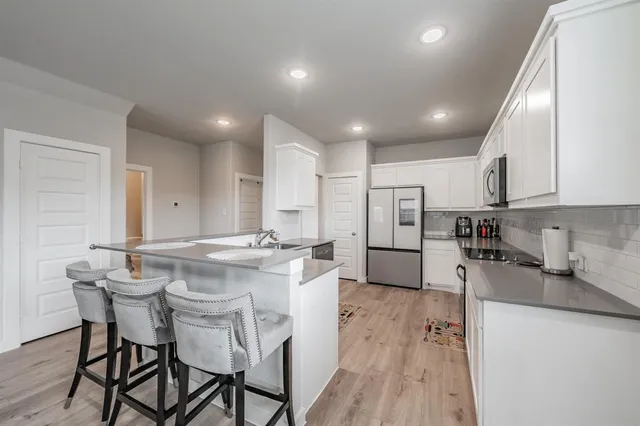 a kitchen with stainless steel appliances granite countertop a sink and a refrigerator