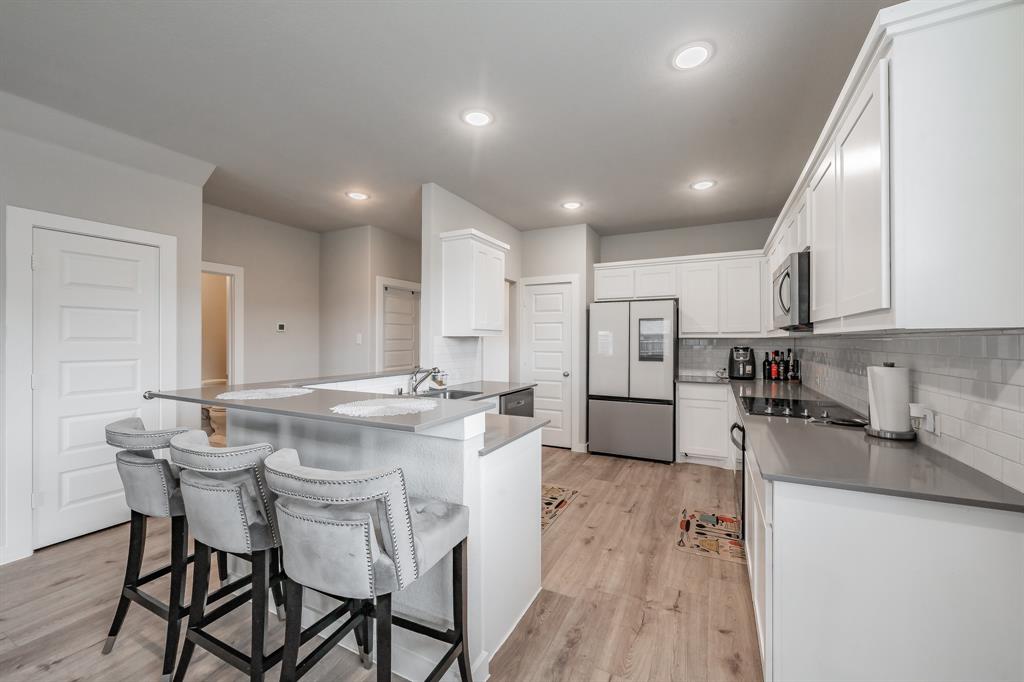 3202 Glorioso Drive Royse City, TX 75189 - Photo 24 of 40 a kitchen with stainless steel appliances kitchen island granite countertop a sink and cabinets