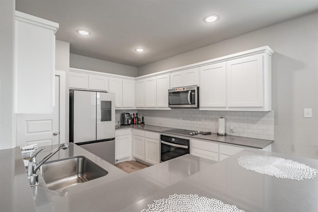 3202 Glorioso Drive Royse City, TX 75189 - Photo 26 of 40 a kitchen with stainless steel appliances granite countertop a sink and a refrigerator