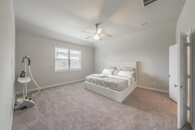 a bedroom with a bed and a ceiling fan