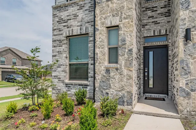 front view of a brick house with a small yard