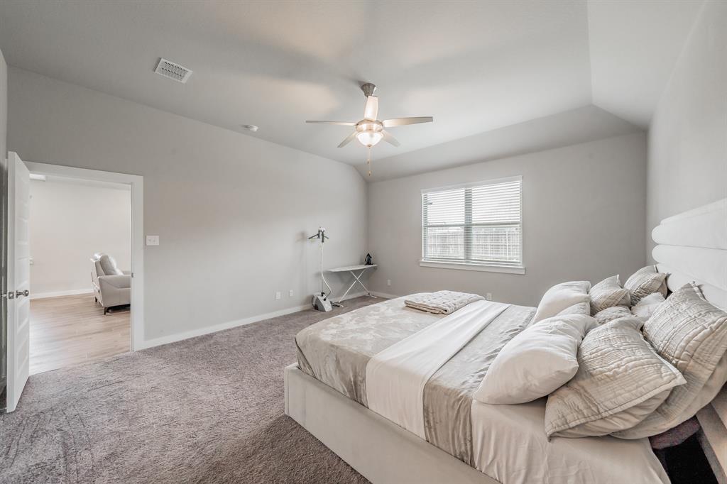 3202 Glorioso Drive Royse City, TX 75189 - Photo 31 of 40 a bedroom with a bed and a chandelier